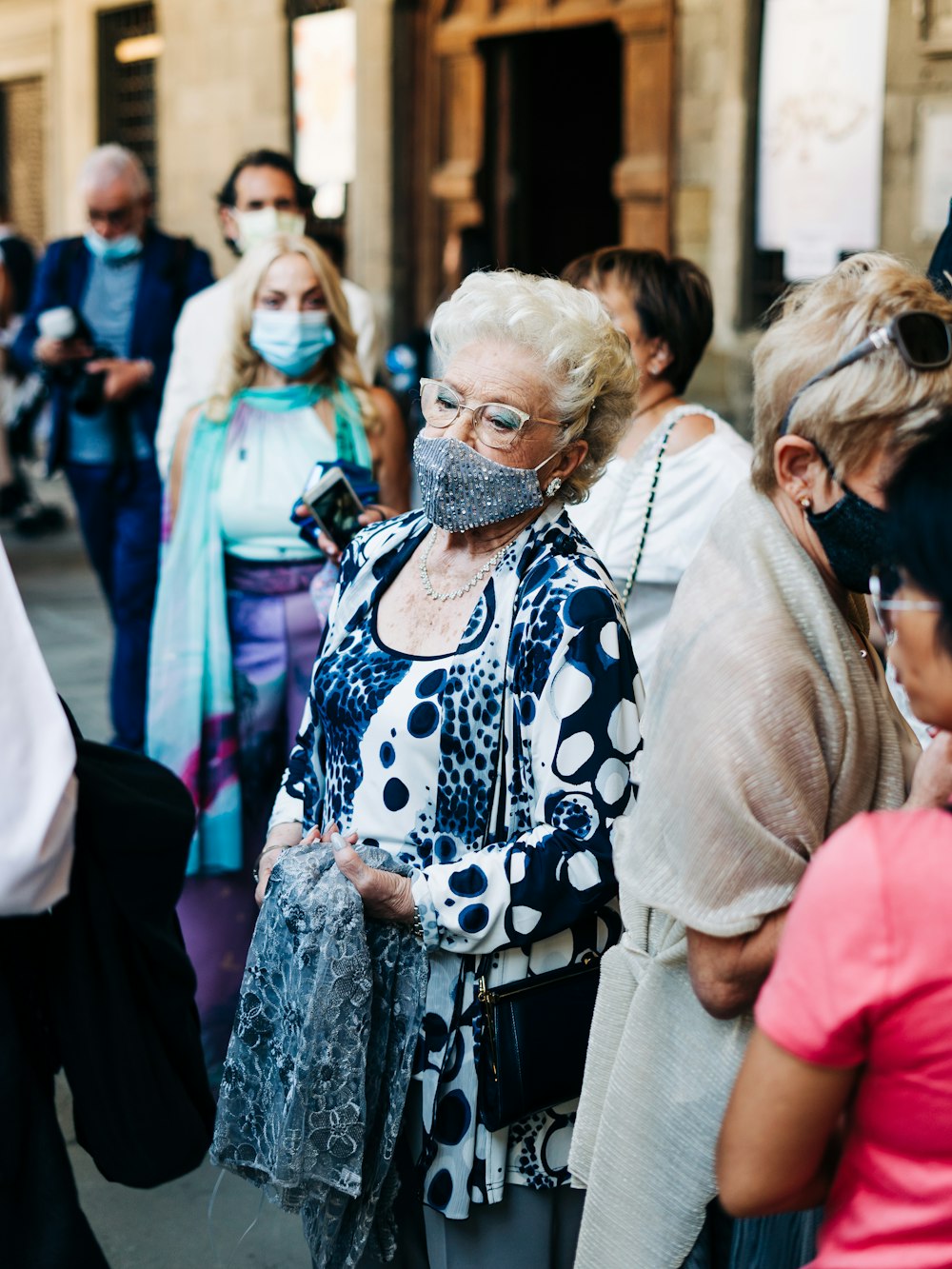 donna in abito floreale bianco e nero in piedi accanto alla donna in camicia rosa