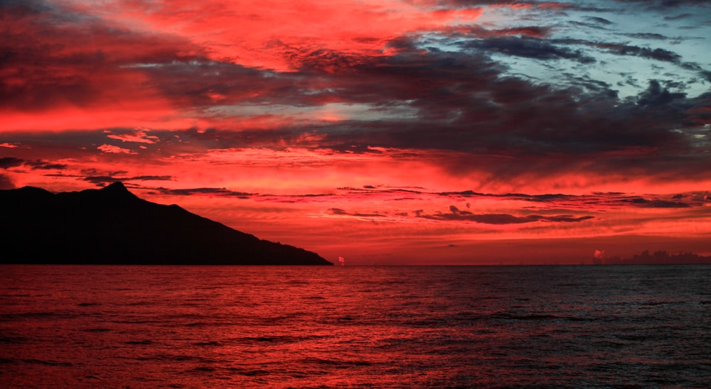 body of water under cloudy sky during sunset