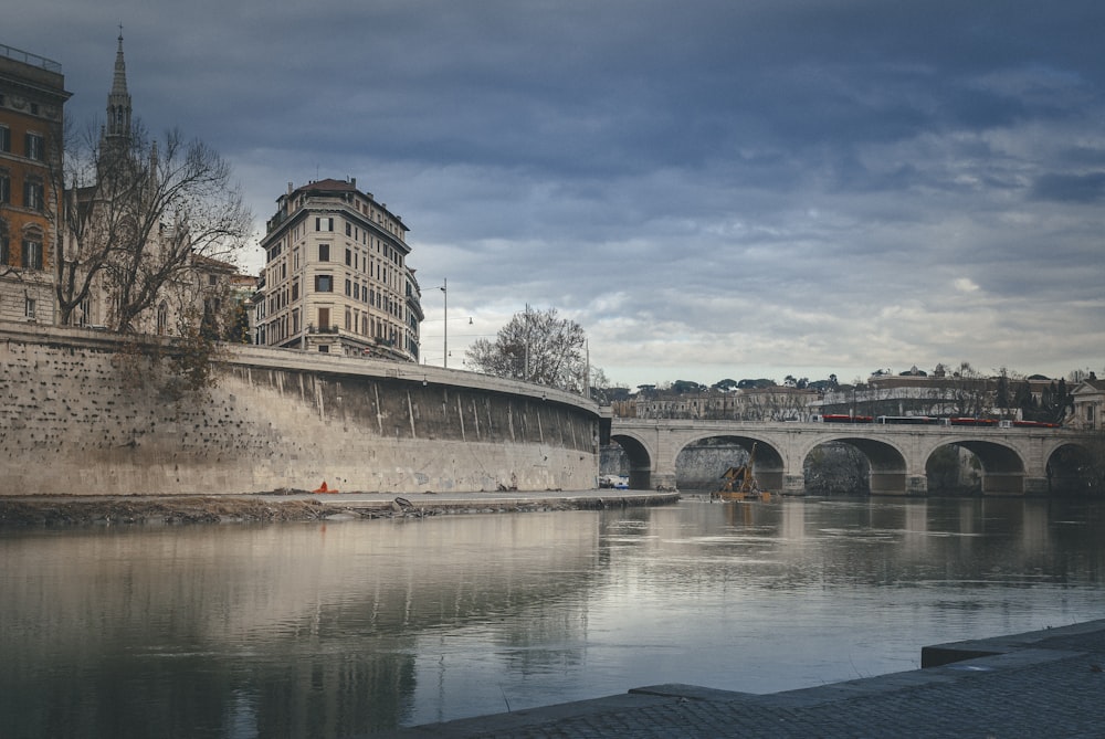 edificio in cemento bianco vicino allo specchio d'acqua sotto il cielo blu durante il giorno