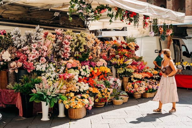 A vibrant wholesale flower market stall filled with colorful blooms and lush greenery.
