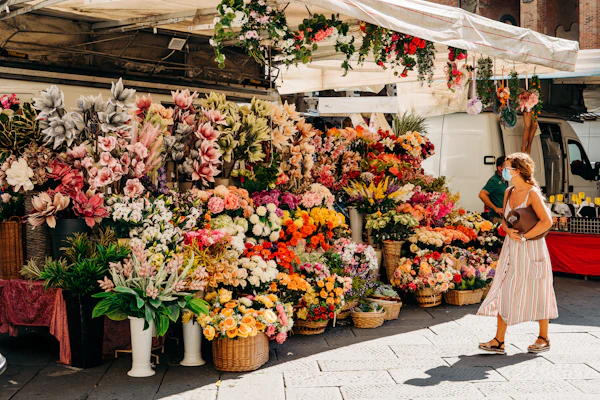 Baskets of yellow, pink and red flowers at a market stall