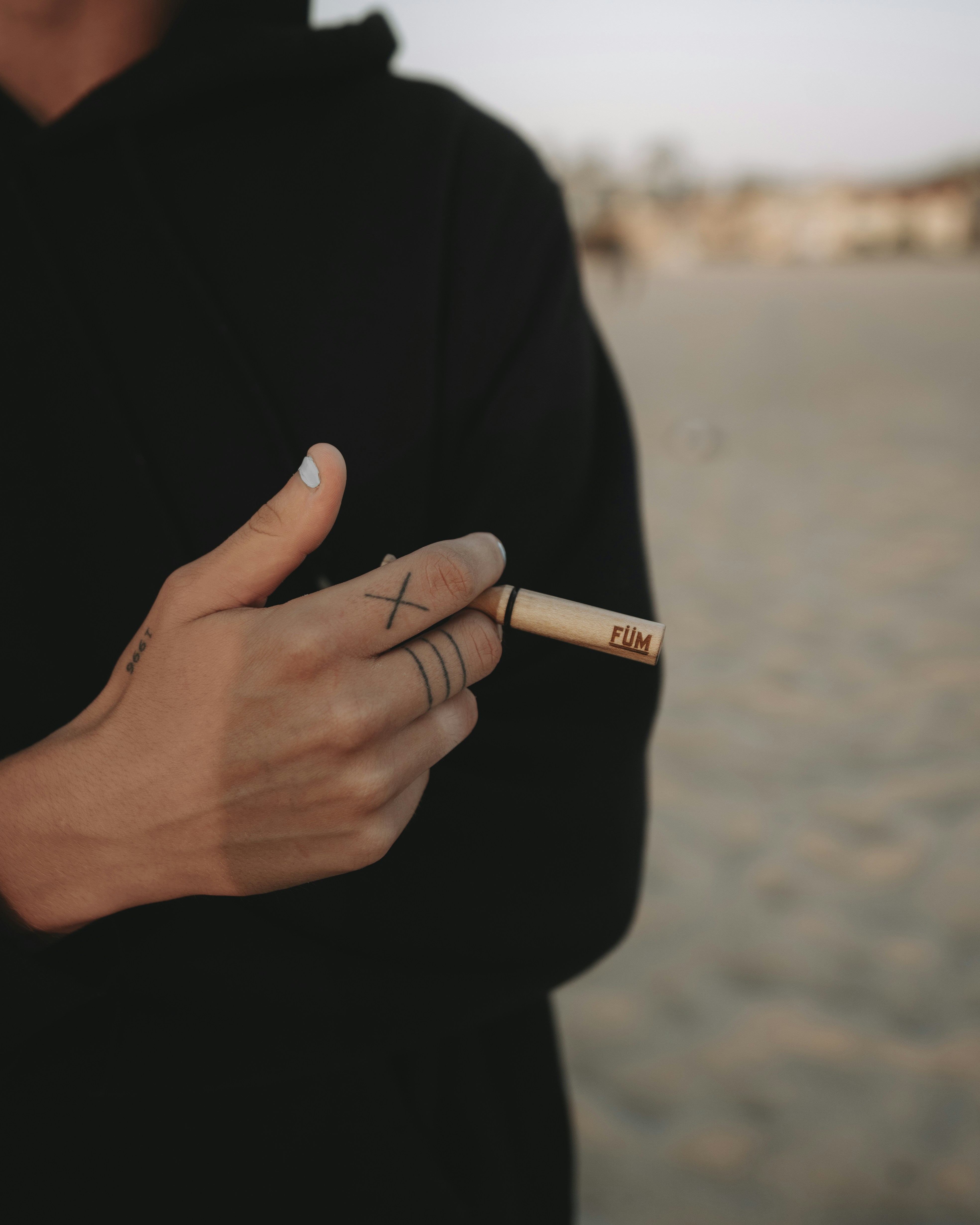 person holding cigarette stick during daytime