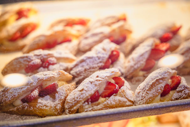 A tray of assorted pastries with golden crusts and powdered sugar dusting.