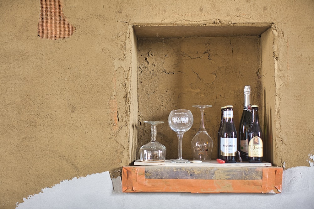 clear wine glass beside bottle on white table