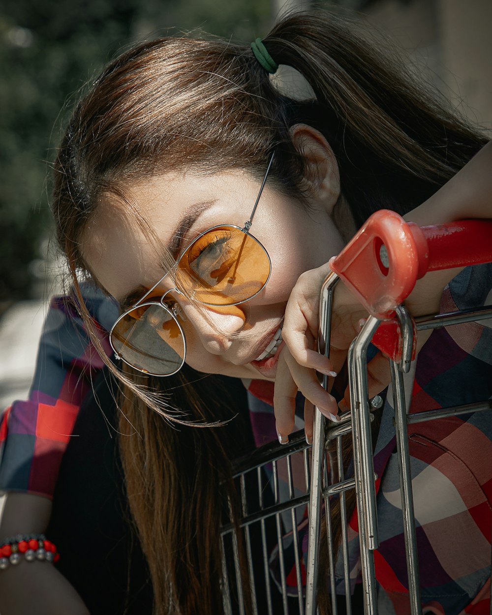 woman in red and white plaid shirt wearing brown sunglasses