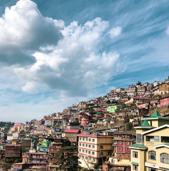 city with high rise buildings under blue and white cloudy sky during daytime in Shimla India