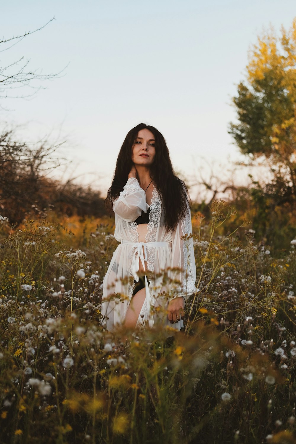 woman in white dress standing on yellow flower field during daytime