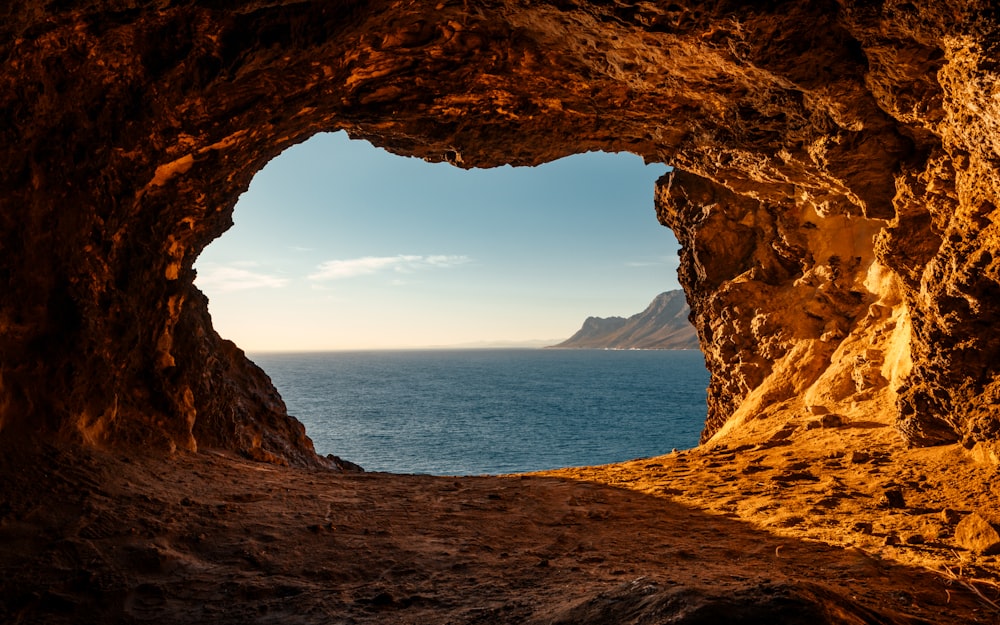 日中の水域近くの茶色の洞窟