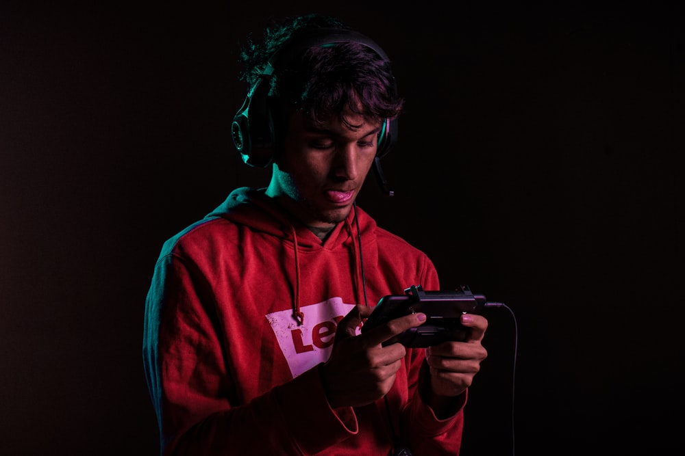 man in red hoodie holding black semi automatic pistol