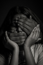 grayscale photo of woman covering her face with her hands