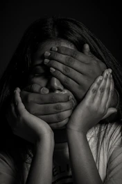 grayscale photo of woman covering her face with her hands