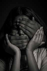 grayscale photo of woman covering her face with her hands
