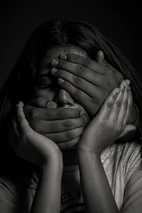 grayscale photo of woman covering her face with her hands