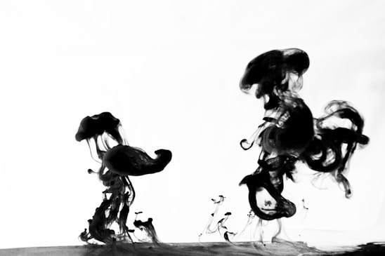 A close-up of colorful ink droplets swirling together on a white surface, symbolizing creativity and precision.