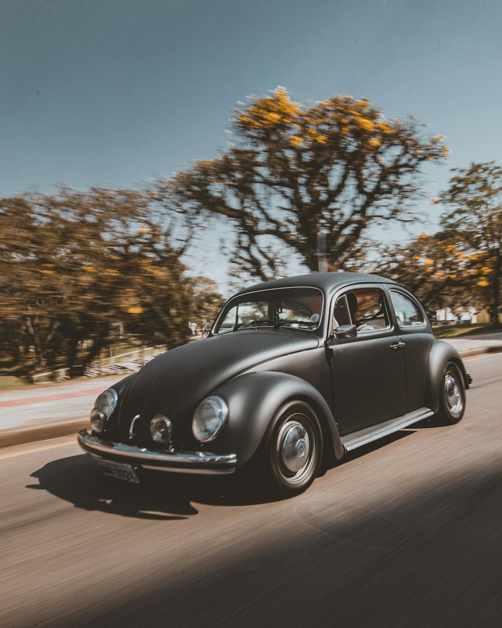 black volkswagen beetle on road during daytime