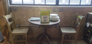 High-contrast industrial-style dining table set against a deep charcoal wall.