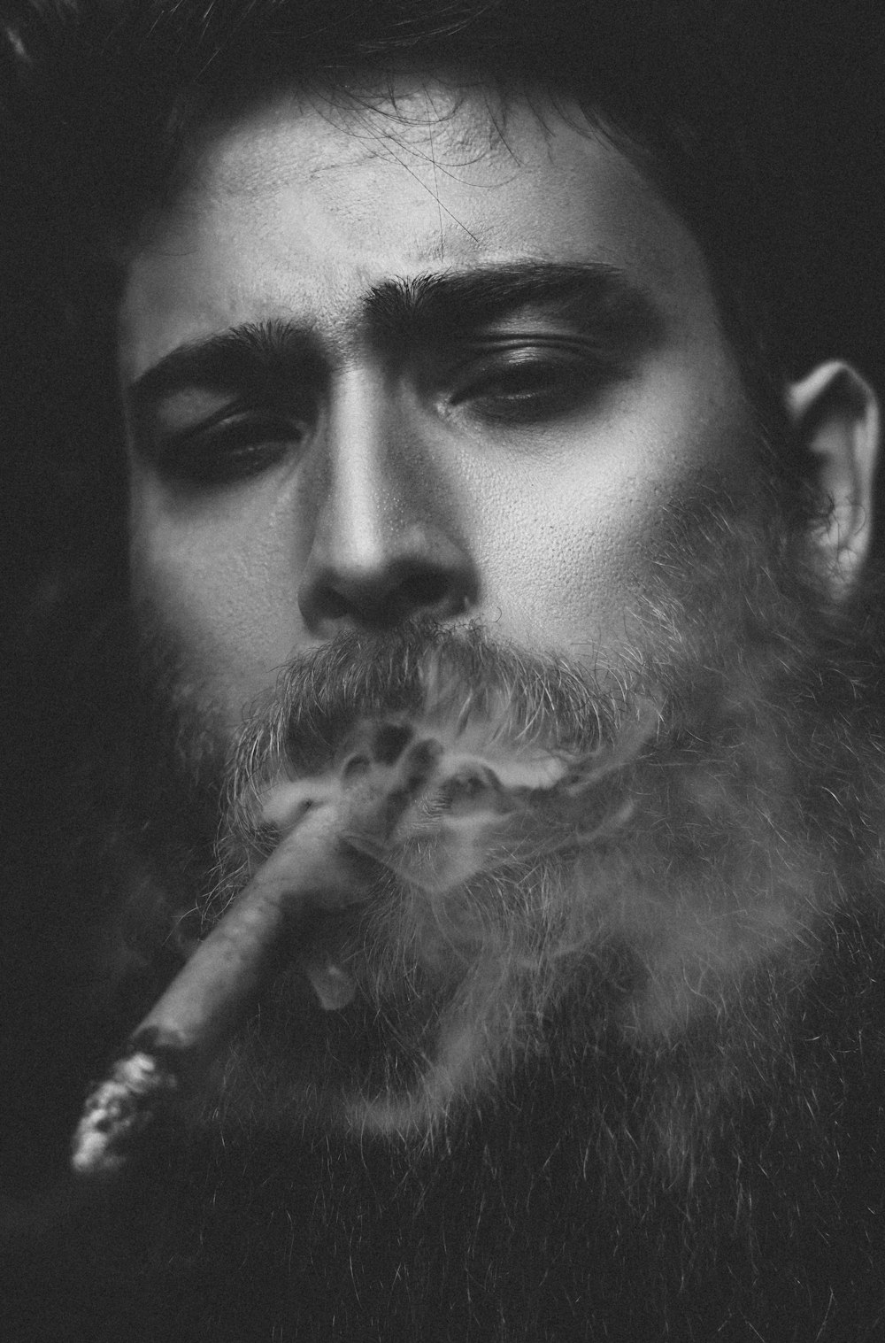 man smoking cigarette in grayscale photography