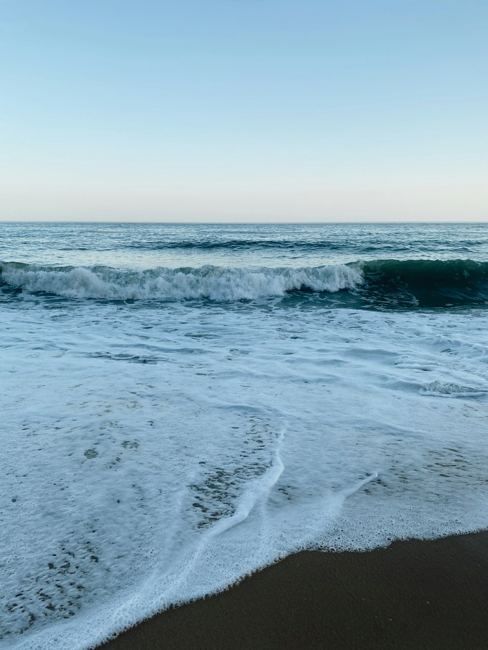 ocean waves crashing on shore during daytime