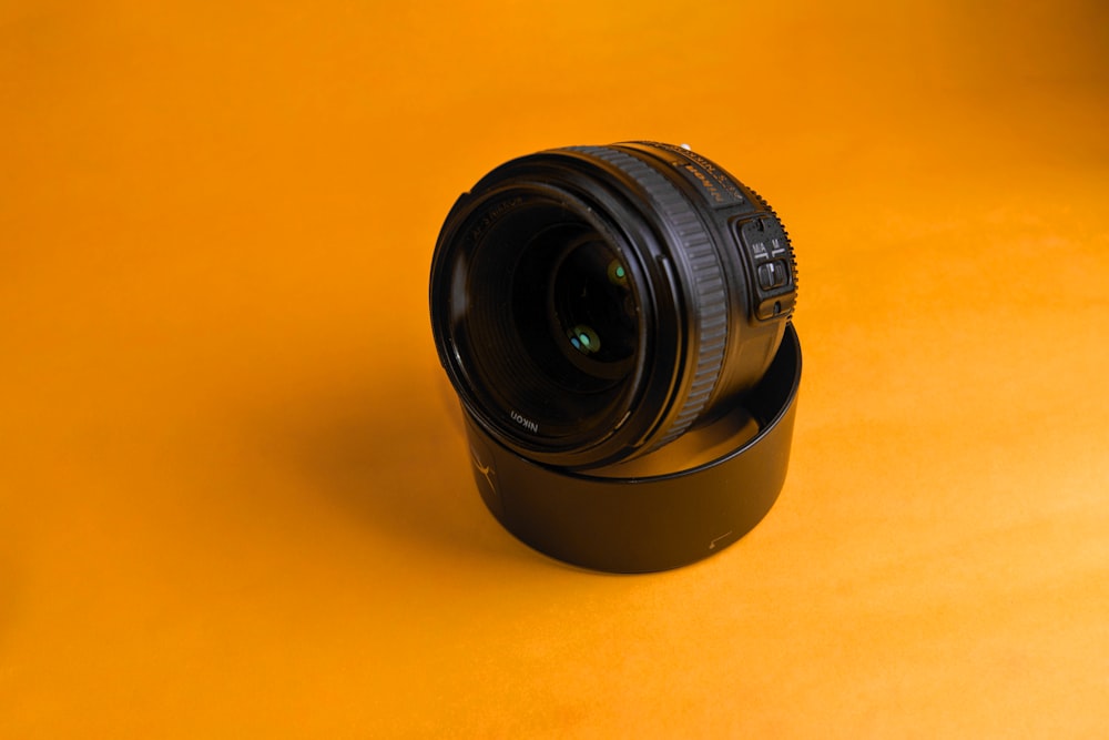 Obiettivo della fotocamera nero su superficie gialla