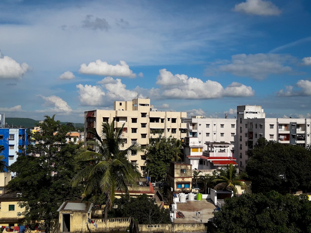 white concrete building near green trees under blue sky during daytime