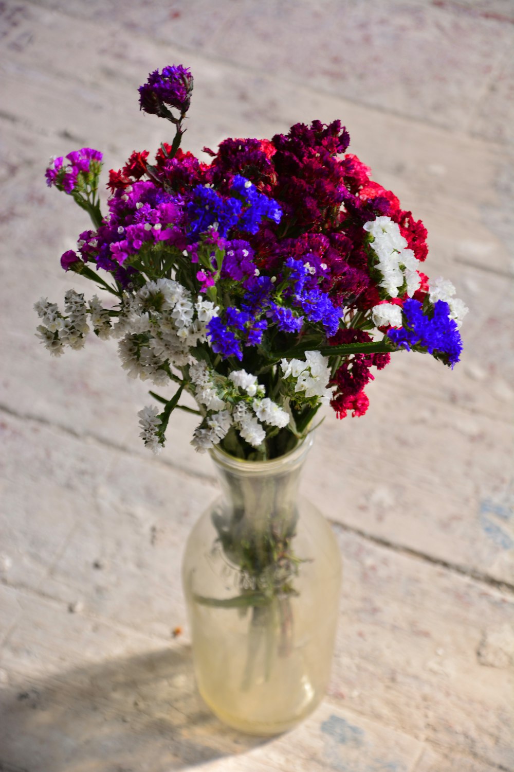 purple flowers in clear glass vase