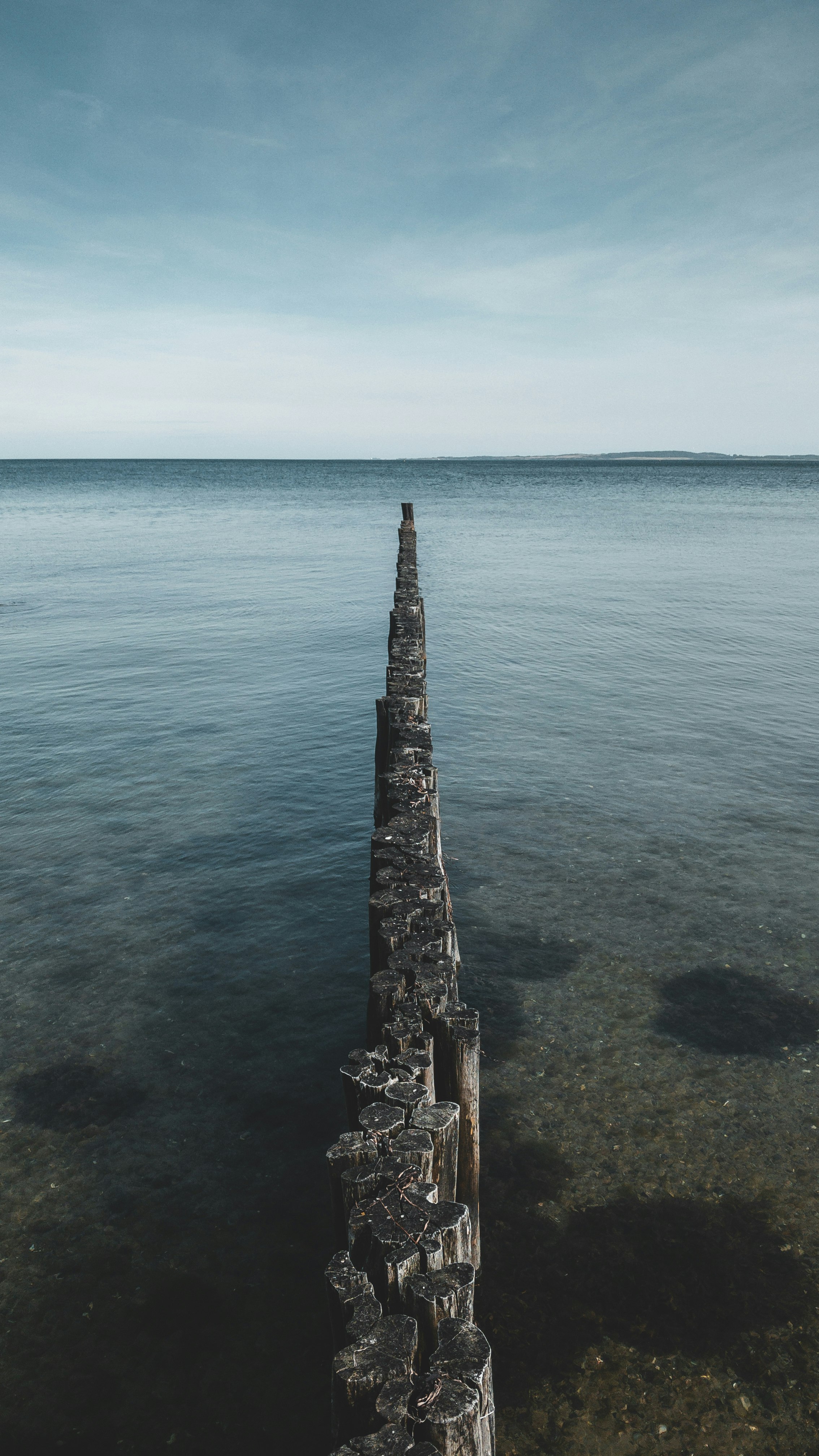 gray concrete dock on blue sea under blue sky during daytime