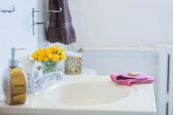 yellow and pink towel on white ceramic sink