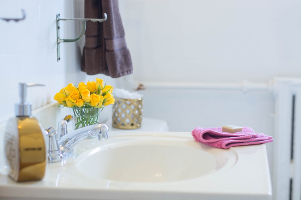 yellow and pink towel on white ceramic sink