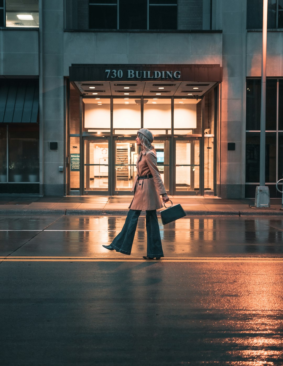 woman in black coat walking on sidewalk during daytime