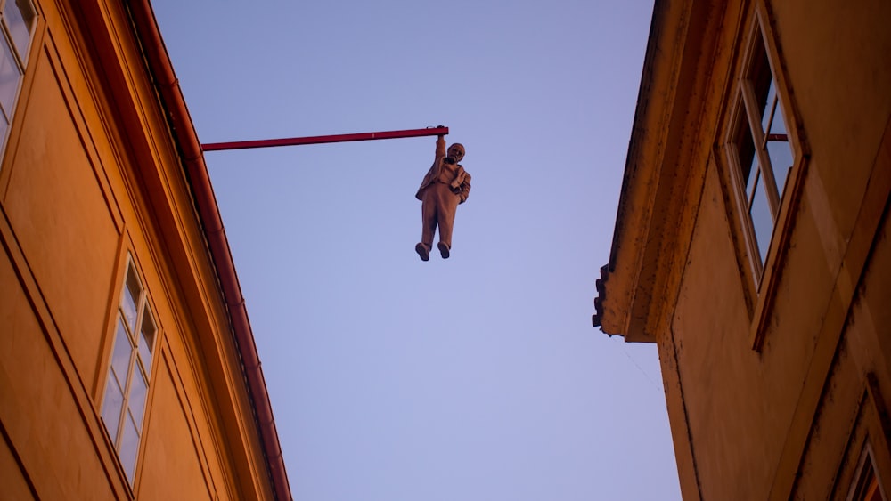 hombre en pantalones cortos negros saltando en un poste de madera marrón durante el día