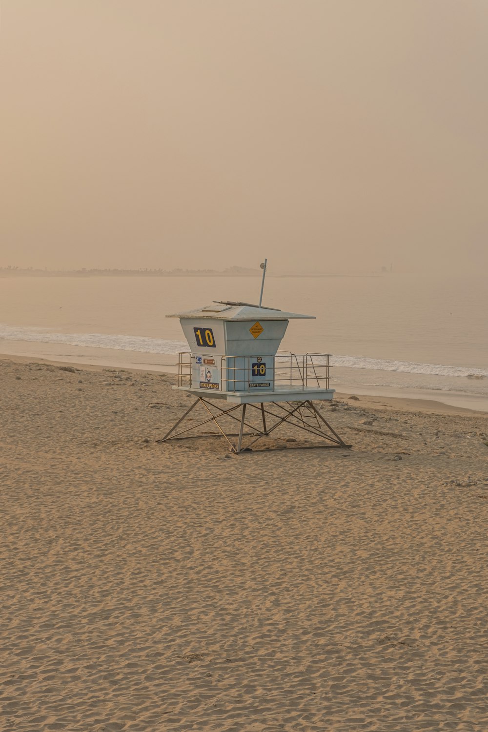 white lifeguard house on beach during daytime