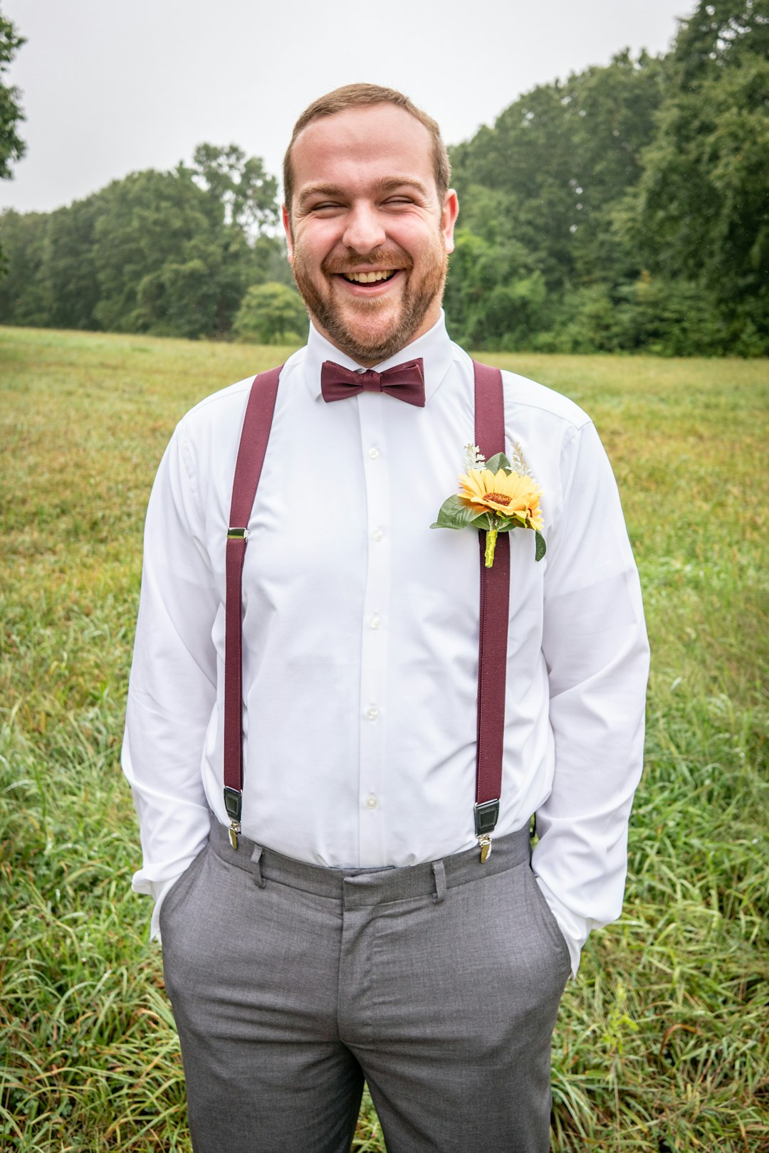 man in white dress shirt and gray pants standing on green grass field during daytime