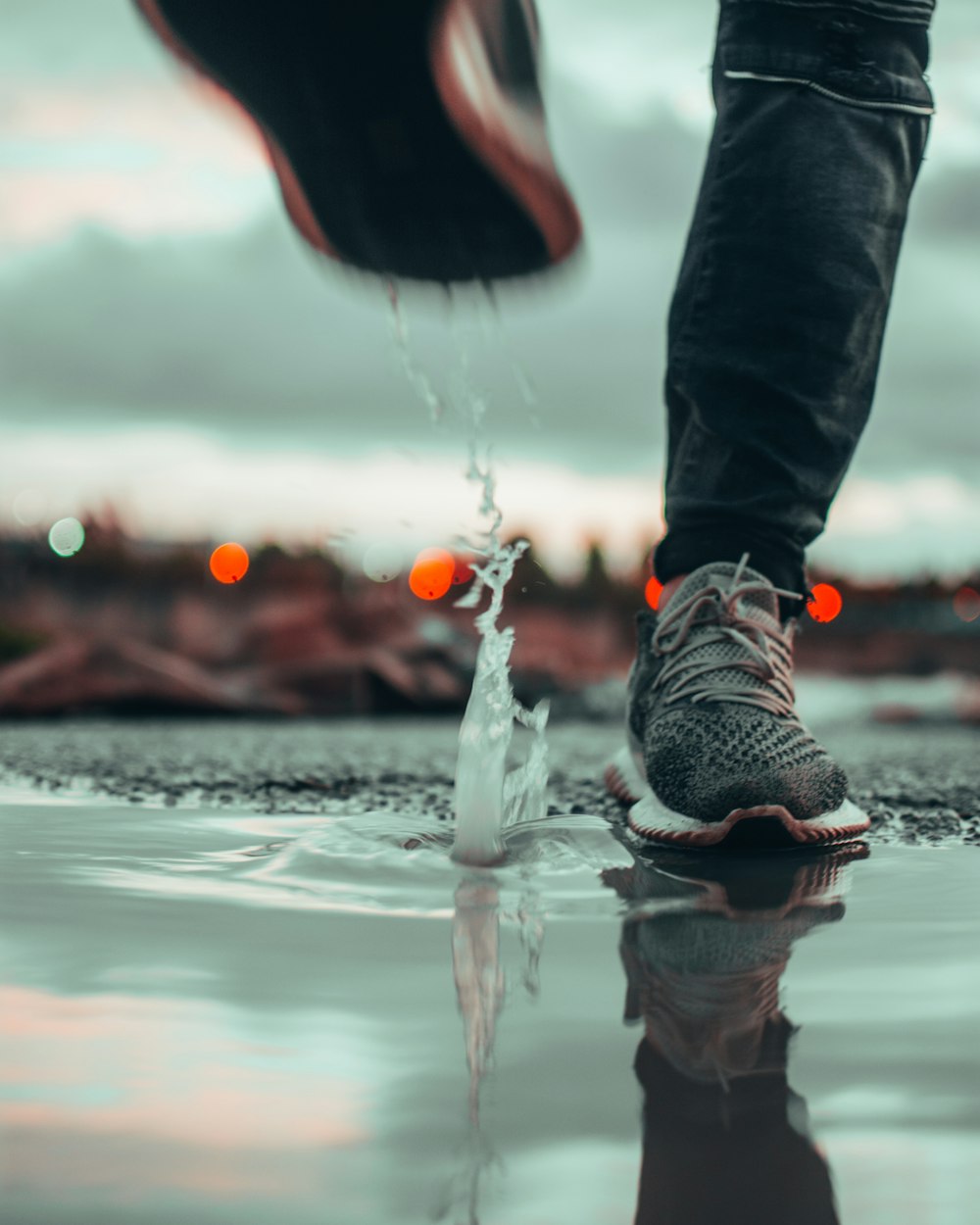 person in black pants and gray nike sneakers playing water