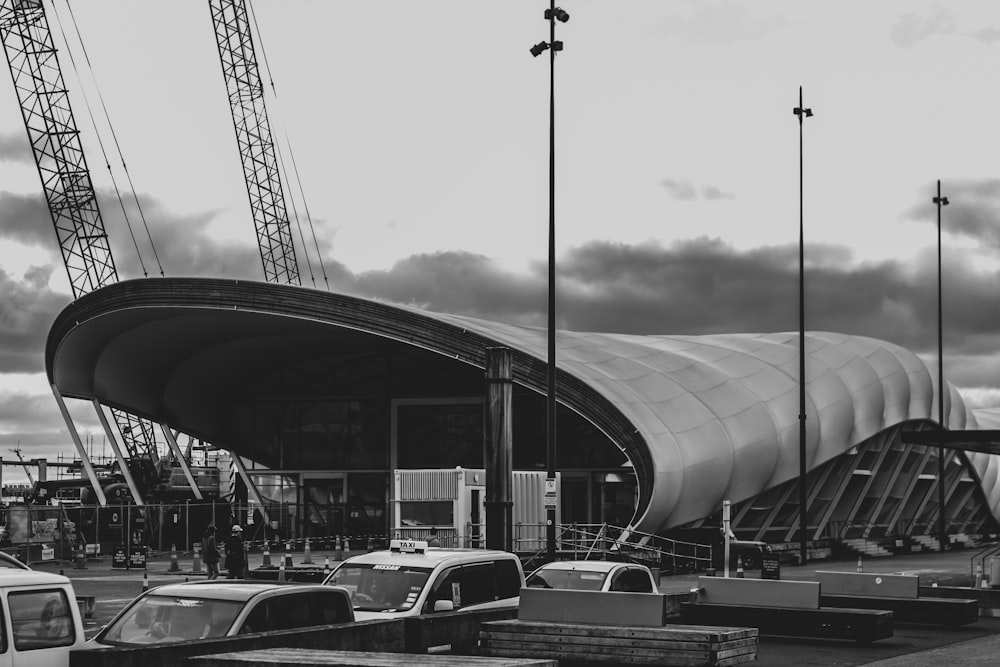 grayscale photo of cars parked near building