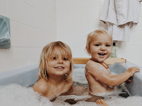 A group of children smiling in a clean bathroom.