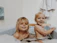 Smiling mother and child brushing teeth together in a bright bathroom.
