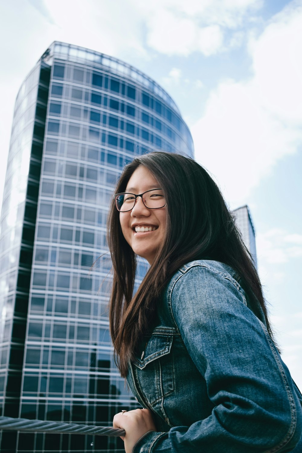 woman in blue denim jacket wearing black framed eyeglasses