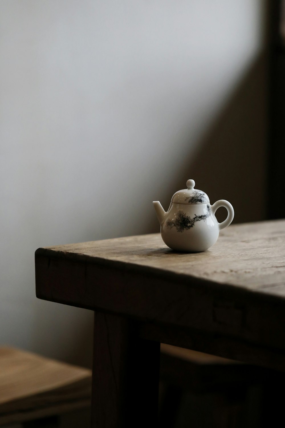 white ceramic teapot on brown wooden table