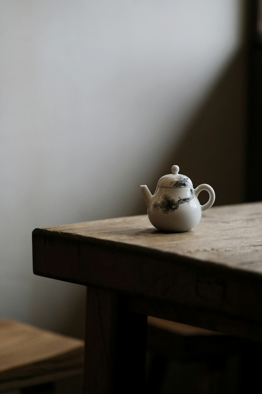 Théière en céramique blanche sur table en bois brun