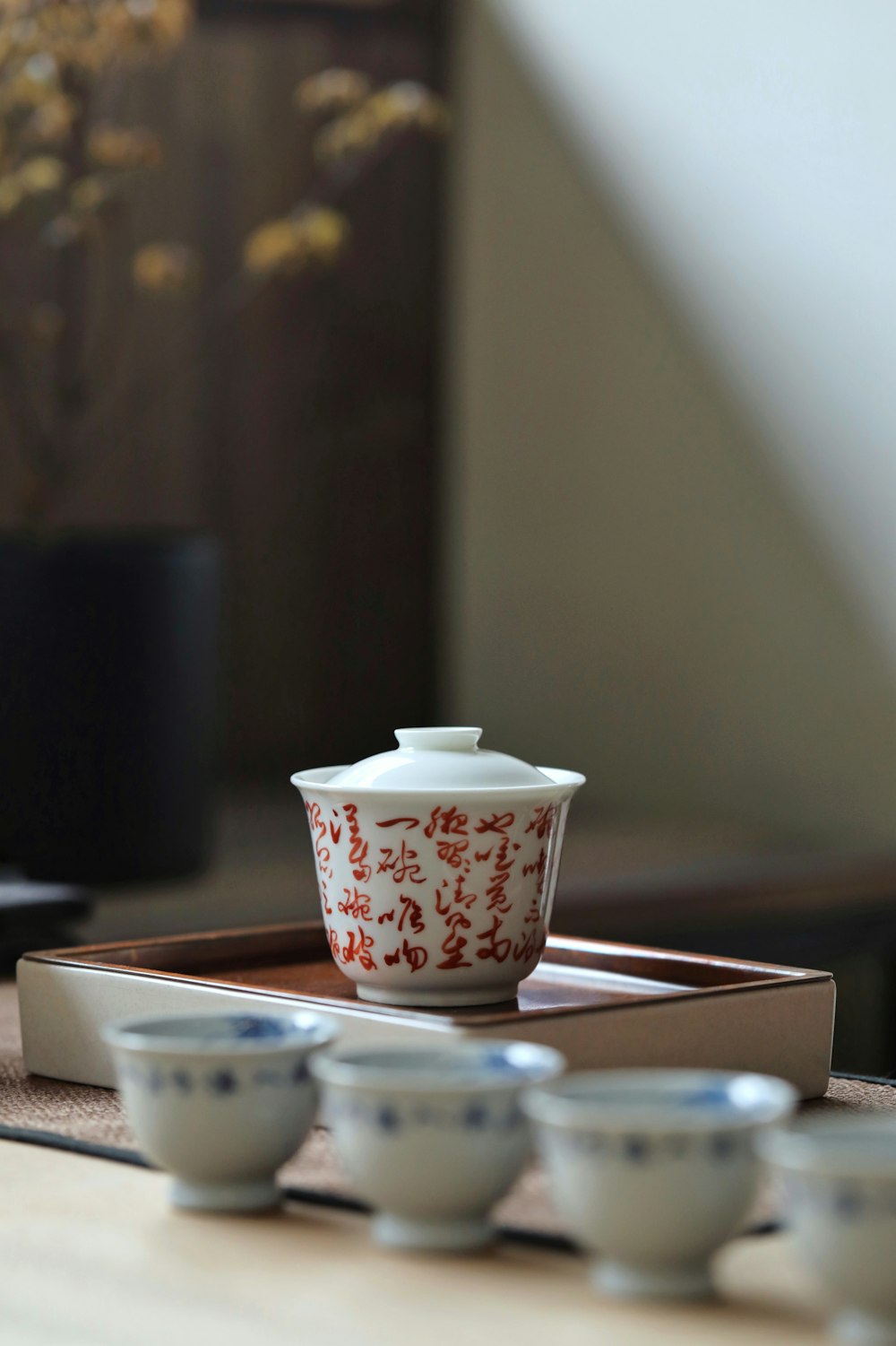 xícara de chá de cerâmica floral branca e vermelha no pires