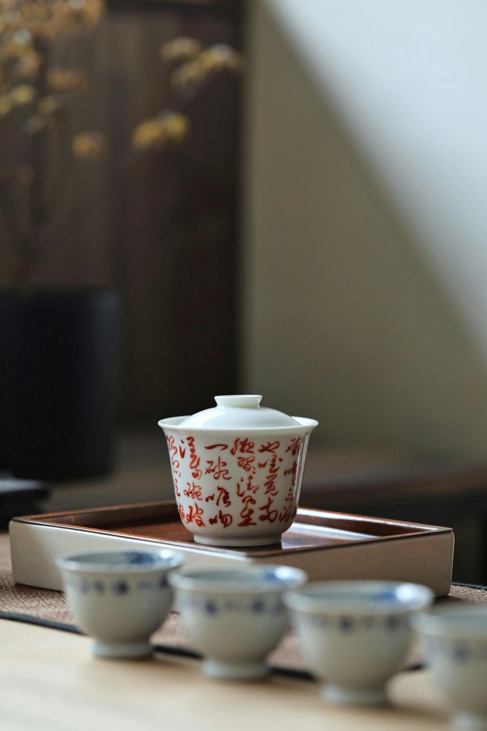 white and red floral ceramic teacup on saucer