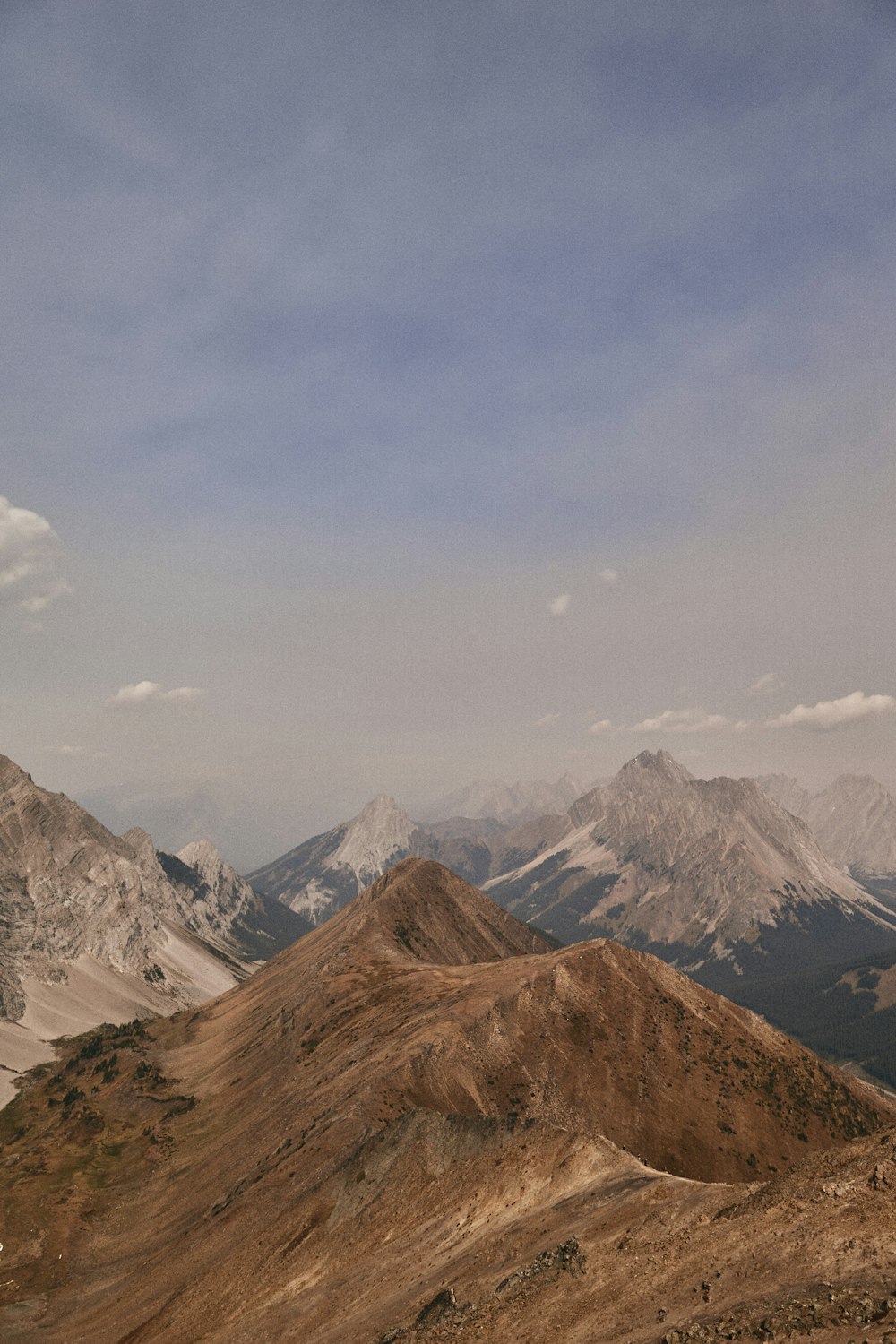 brown and white mountains under white clouds during daytime