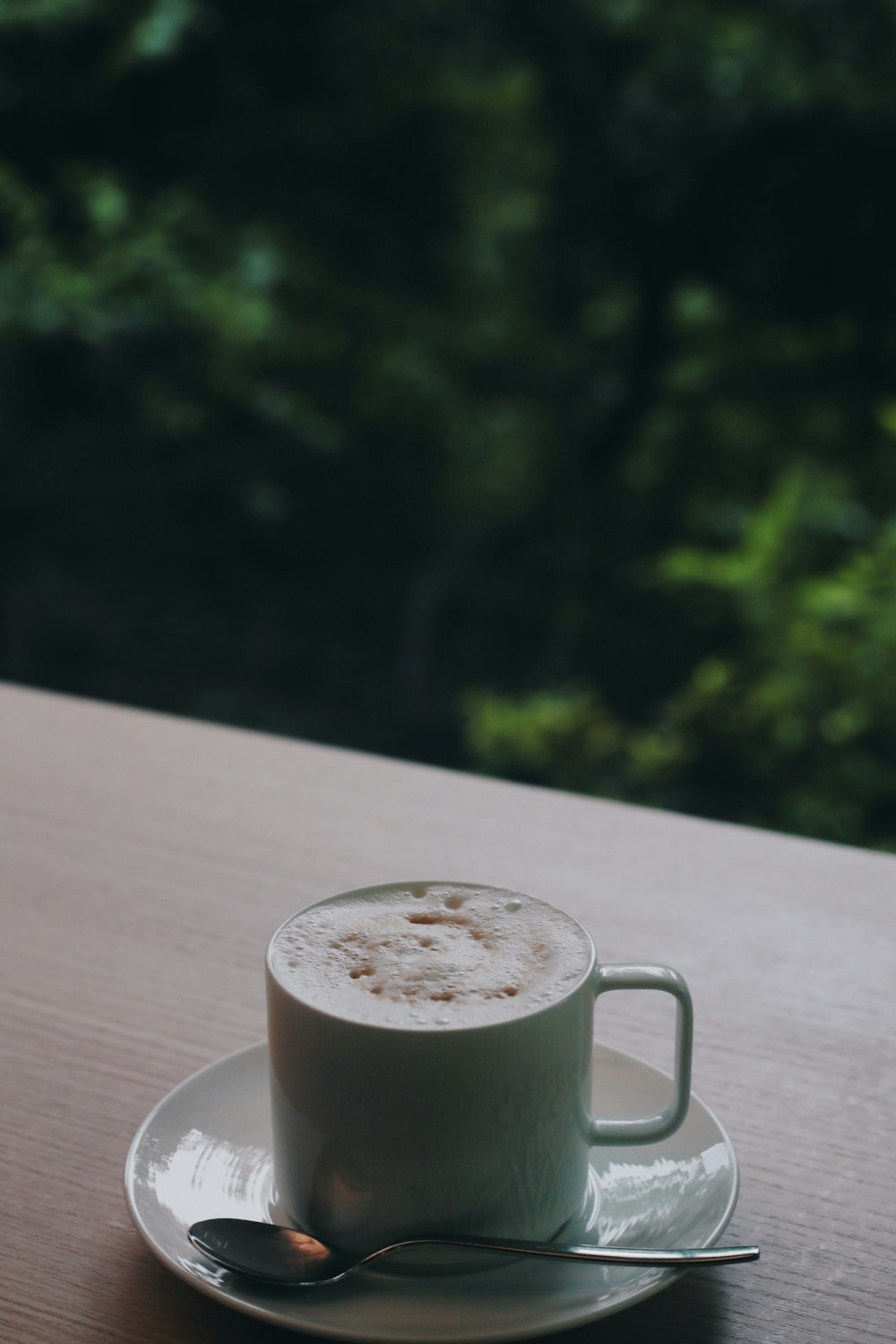 white ceramic mug on brown wooden table