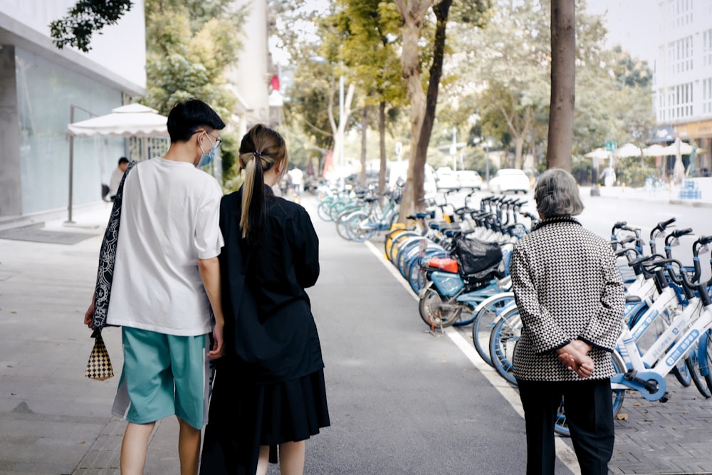 man in white t-shirt standing beside woman in black dress