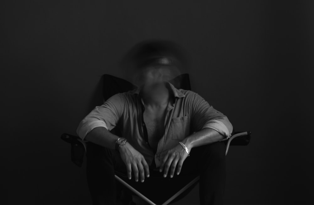 man in black long sleeve shirt sitting on chair