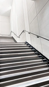 A stairway wall lamp with clean lines highlighting each step in a stylish home.