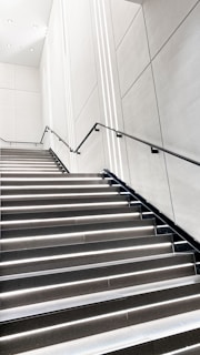 A sleek, modern metal staircase with clean lines installed in a bright, airy home.