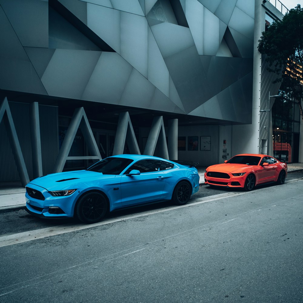 blue coupe parked beside orange car