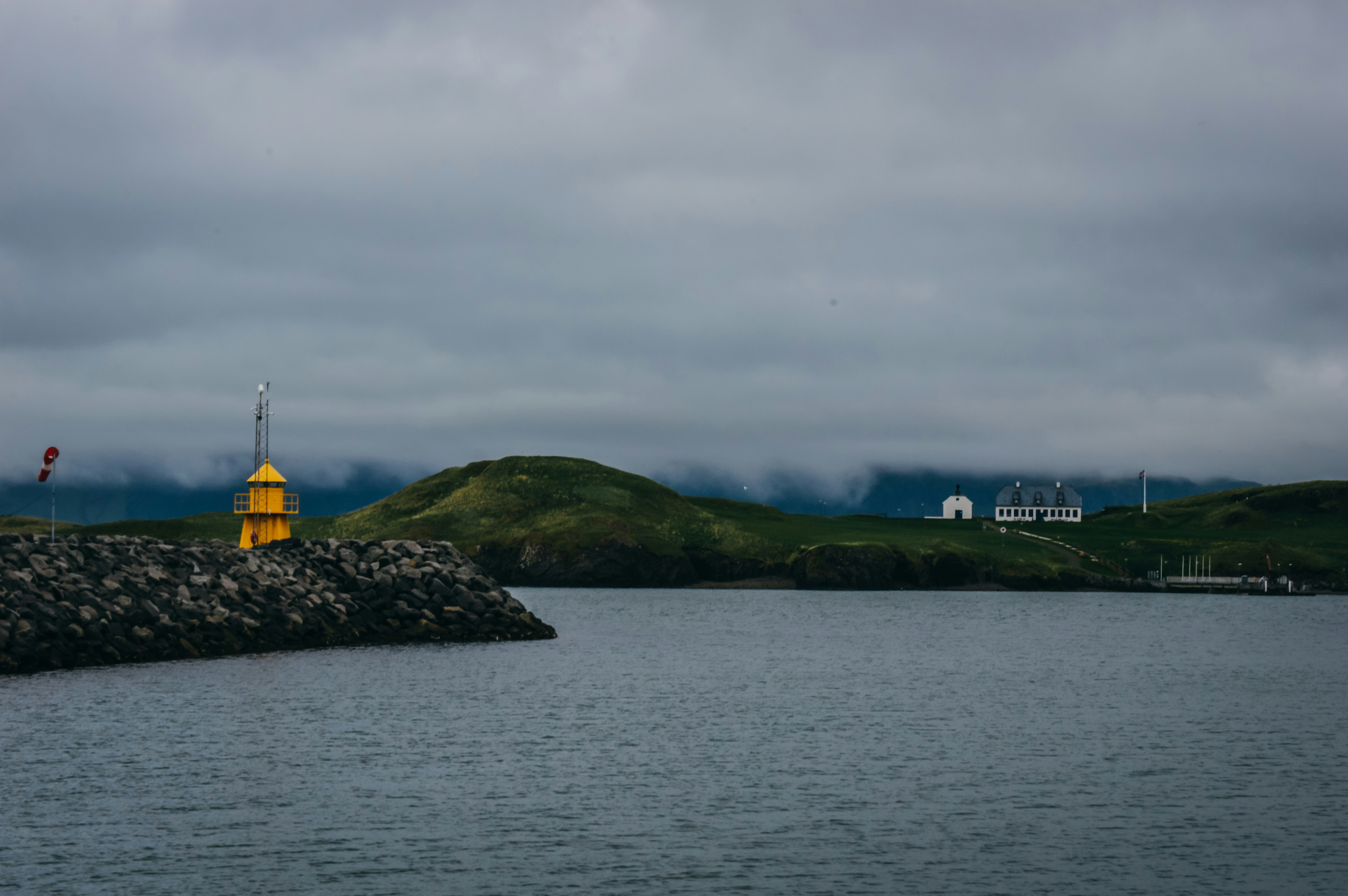 yellow and black tower on green grass field near body of water