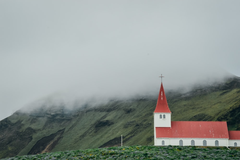 Iglesia de hormigón rojo y blanco sobre campo de hierba verde